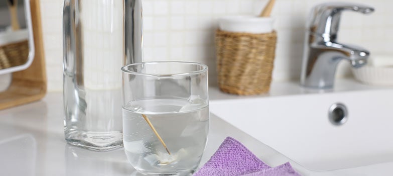 Vaso de agua tibia mezclado con vinagre blanco, ideal para eliminar el olor a orina de mascota