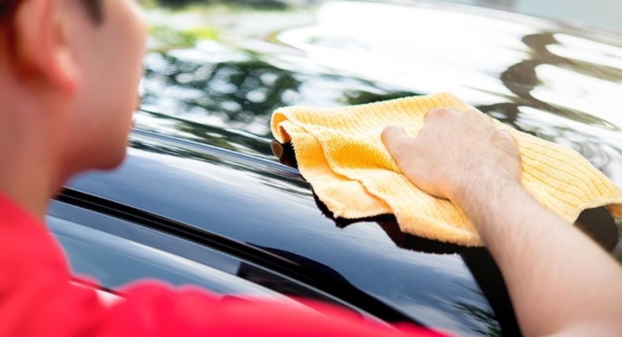 señor limpiando carro