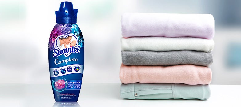 Suavitel Complete Todo en Uno, diseñado con tecnología avanzada para reducir arrugas, acompañado de una fila de prendas  dobladas.