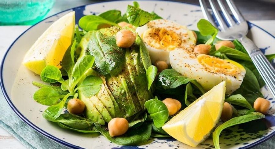 recipiente profundo con una capa de espinacas, luego de naranjas, seguidamente de aguacates