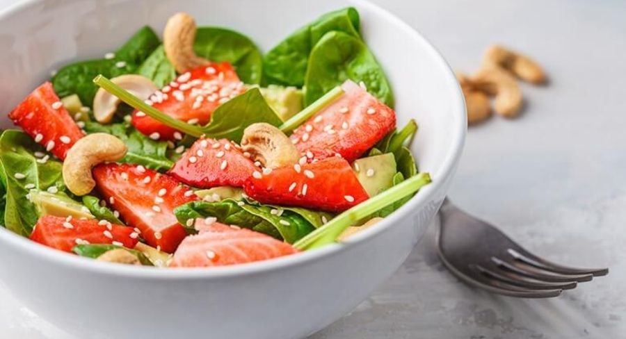 ensaladera con la espinaca y mezcla con la rúcula, agrega las fresas y revuelve junto con las nueces, sirve y decora con el aderezo