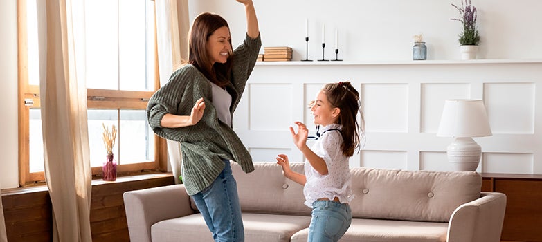 Madre e hija bailando disfrutando del perfume de ropa