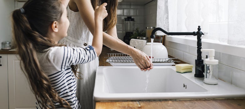 Mujer lavando trastes con axion liquido