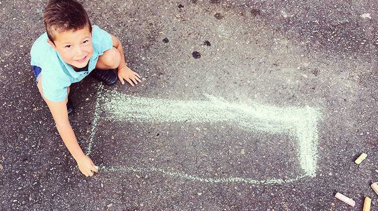 niño rayando con tiza el suelo