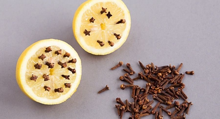 corta los limones por la mitad e inserta los clavos de olor