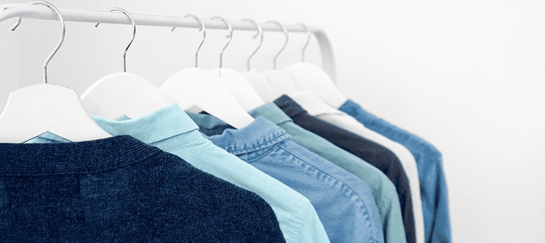 Camisas colgadas en un gancho, conservadas con todos los cuidados para la ropa necesarios para mantener su calidad y apariencia.