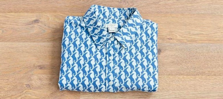 camisa azul de caballos de mar doblada de forma clasica