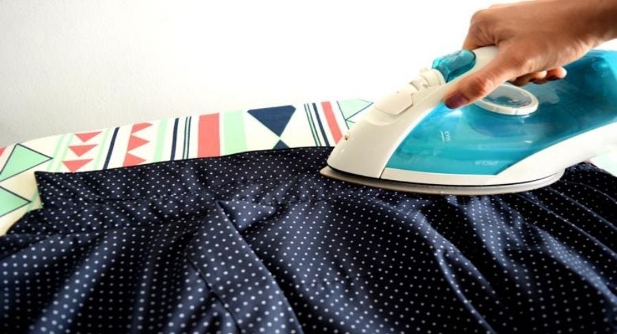 Persona planchando una camisa