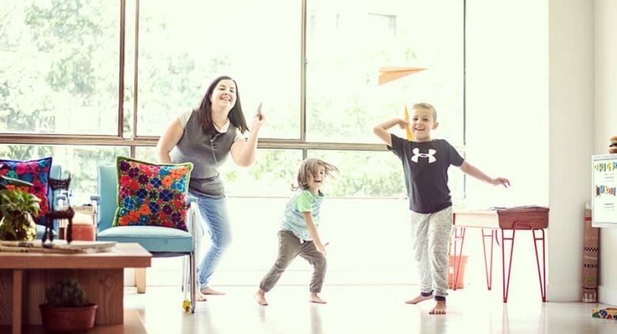 Mamá e hijos jugando con aviones de papel