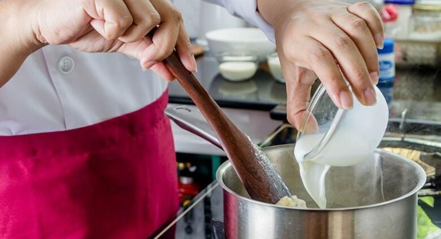 Agregando la leche, la leche evaporada y la condensada en el agua caliente