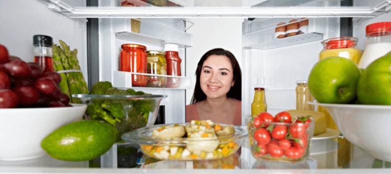 Mano enguantada realizando una limpieza profunda del refrigerador.