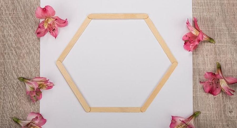 Hoja de papel formando un hexagono con palitos de paleta.