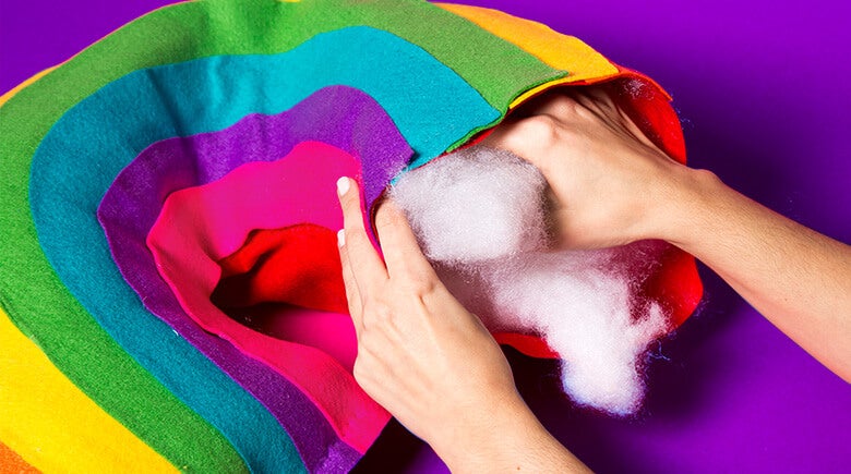 Manos rellenando un almohadon