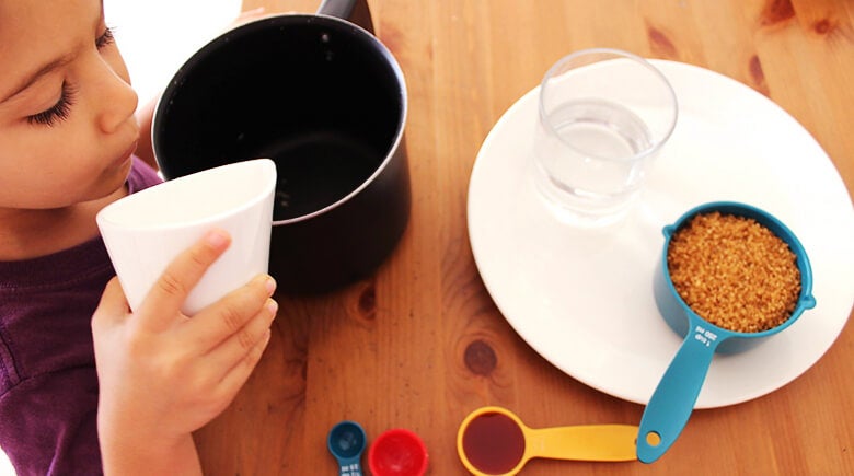 niño aplicando liquido a la olla