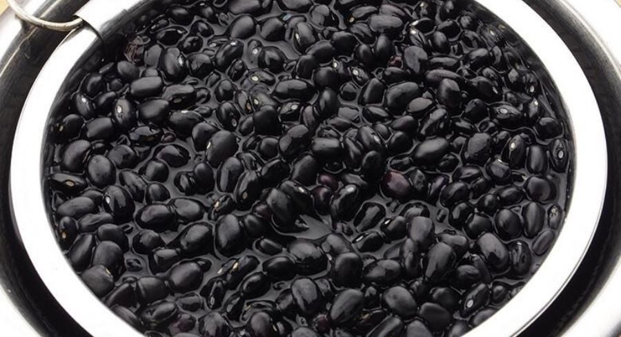 frijoles oscuros en liquido de cerca