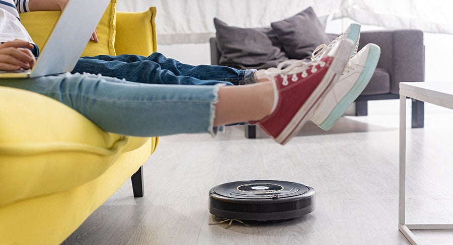 Imagen 6 mamá e hijo sentados en la sala con robot de limpieza trabajando