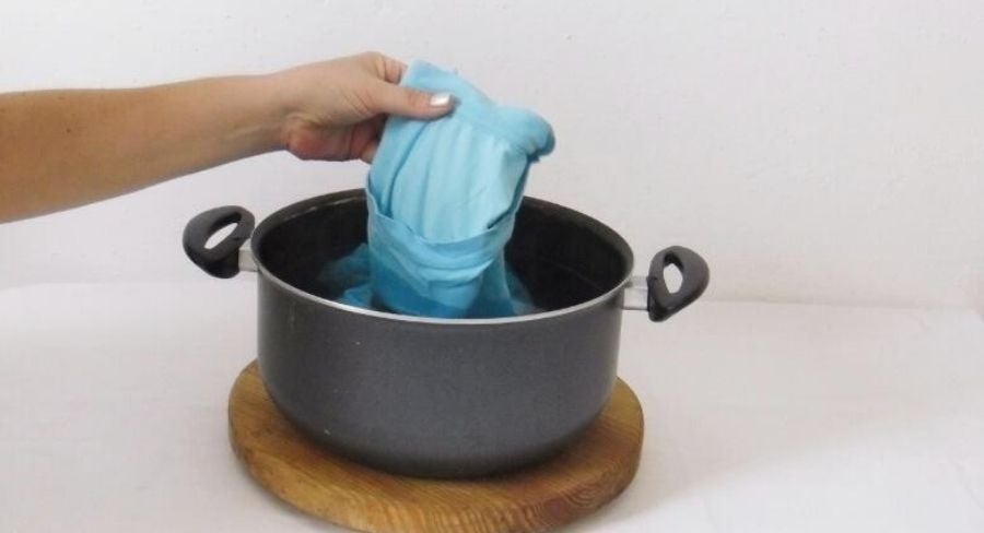 camisa azul dentro de la olla con agua hirviendo