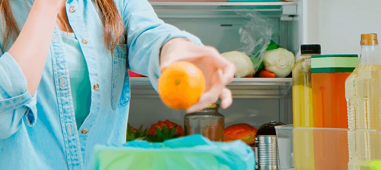 Persona lavándose las manos después de limpiar el refrigerador.