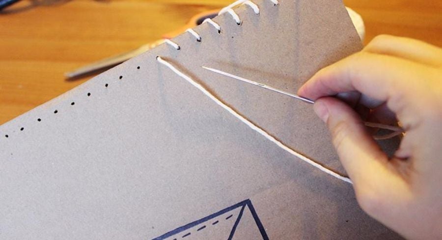 Cosiendo las dos caras del portafolio en cartón 