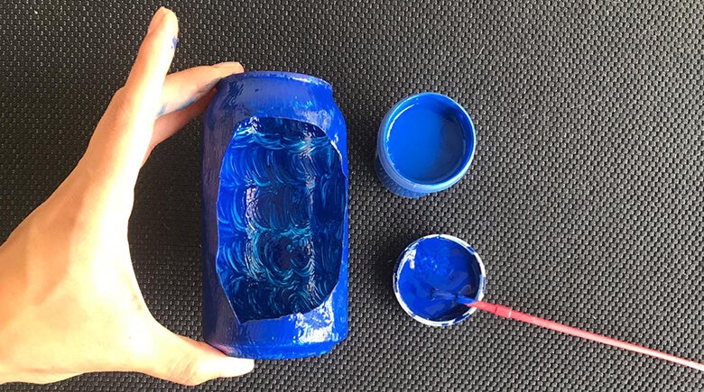 mano sosteniendo lata y pintando