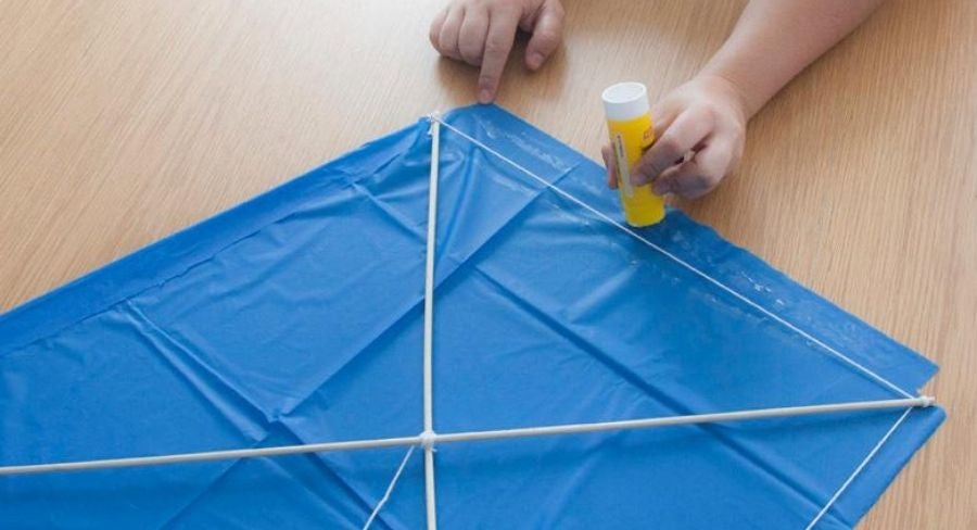 Pegando el excedente de la tela sobrante para el papalote