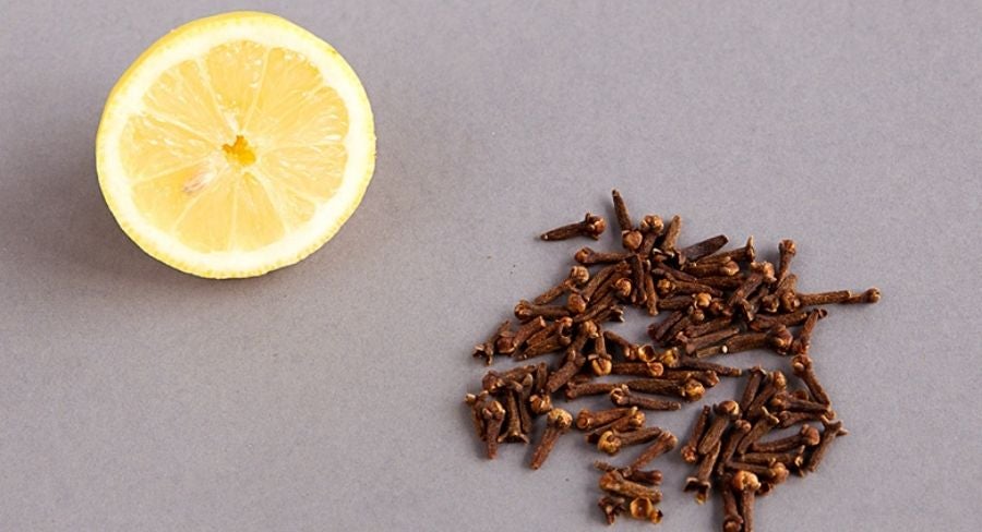Limón partido a la mitad y clavos de olor 