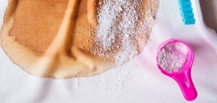 Prenda de ropa manchadac con jabón en polvo esparcido por encima